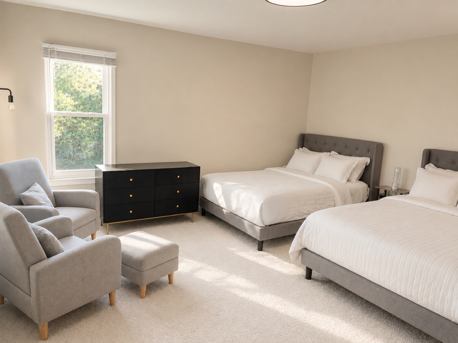 Spacious bedroom with two plush beds and a sitting corner