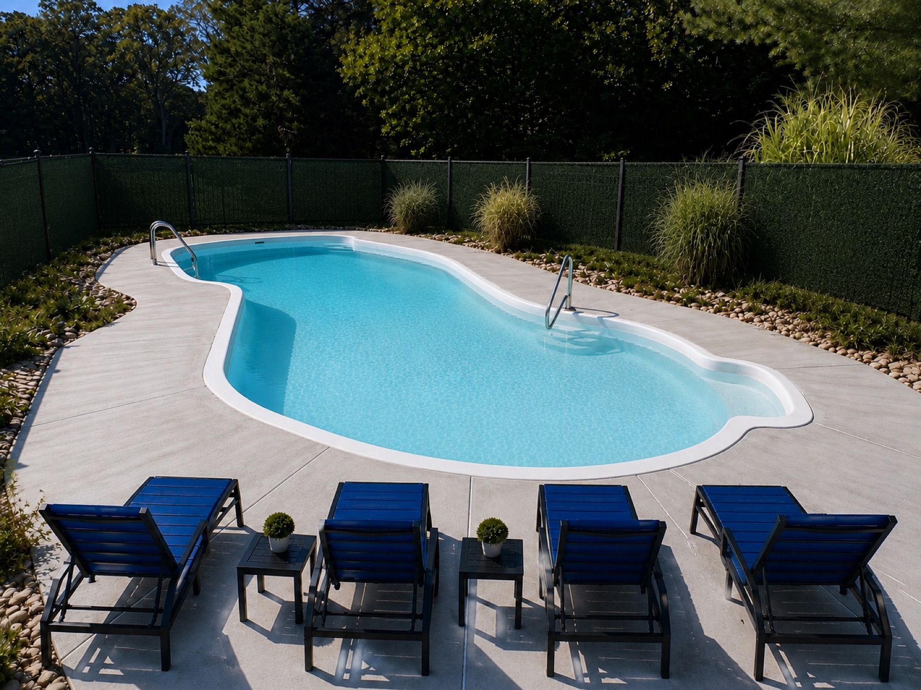 Private in-ground pool with navy loungers and privacy fence